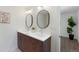 Bright bathroom with double vanity, with dark wood cabinets, and modern fixtures at 5265 W Quarles Dr, Littleton, CO 80128