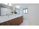 Bright bathroom featuring double sink vanity, marble countertops, modern fixtures, and a window at 5265 W Quarles Dr, Littleton, CO 80128