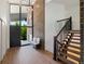 Bright foyer featuring wood floors, modern chandelier, brick accent wall, and staircase to the upper level at 5265 W Quarles Dr, Littleton, CO 80128