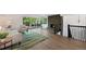 Open-concept living room with a brick fireplace, hardwood floors, a large window, and modern furnishings at 5265 W Quarles Dr, Littleton, CO 80128
