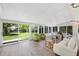 Bright sunroom with wall to wall windows offering backyard views, wood laminate floors, and comfortable seating at 5265 W Quarles Dr, Littleton, CO 80128