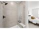 Modern tiled shower features a glass door and a built-in seat, with bedroom view at 8242 S Pierson St, Littleton, CO 80127