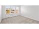 Bright bedroom with three windows and neutral carpet flooring, offering ample natural light at 8242 S Pierson St, Littleton, CO 80127