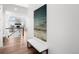 Bright entryway features a white bench, modern art, and gleaming hardwood floors leading to living area at 8242 S Pierson St, Littleton, CO 80127
