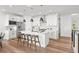 Modern kitchen with white cabinets, stainless appliances, and a large central island at 8242 S Pierson St, Littleton, CO 80127
