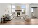 Bright living room features a fireplace, three large windows, and hardwood floors at 8242 S Pierson St, Littleton, CO 80127