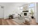 Bright living room features a fireplace, three large windows, and hardwood floors at 8242 S Pierson St, Littleton, CO 80127