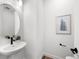 Stylish powder room featuring a pedestal sink, modern faucet, and tasteful wall art at 8242 S Pierson St, Littleton, CO 80127