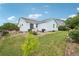 Lovely backyard of light blue home, featuring well-maintained grass and a small tree, perfect for outdoor enjoyment at 13802 Jasmine St, Thornton, CO 80602