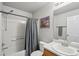 Bathroom featuring a shower/tub combo with curtain, a single sink, and a framed picture, blending function and style at 13802 Jasmine St, Thornton, CO 80602