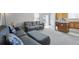 Comfortable living room featuring a gray sofa and view of the kitchen with wood cabinets at 13802 Jasmine St, Thornton, CO 80602