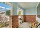 Inviting covered porch featuring brick columns, neutral tones, and space for comfortable seating at 13802 Jasmine St, Thornton, CO 80602