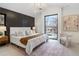 Bright bedroom featuring a stylish accent wall, elegant chandelier, and a large window with neighborhood views at 2961 S Cherokee, Englewood, CO 80110
