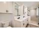 Modern bathroom featuring double sinks, white cabinets, and a glass-enclosed shower at 12196 W Belleview Dr, Littleton, CO 80127