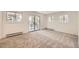 Bright bedroom with neutral carpet, white walls, and sliding glass doors to a balcony at 12196 W Belleview Dr, Littleton, CO 80127