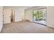 Open bedroom featuring neutral carpet, white walls, and sliding glass doors to a balcony at 12196 W Belleview Dr, Littleton, CO 80127