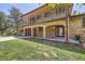 Two-story brick house with balcony and covered entryway, featuring attached garages and a well-manicured lawn at 12196 W Belleview Dr, Littleton, CO 80127