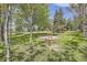 Fire pit on manicured grounds surrounded by mature trees and lush green lawn at 12196 W Belleview Dr, Littleton, CO 80127