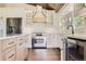 Well-lit kitchen with stainless steel appliances, white cabinetry, and a spacious center island at 12196 W Belleview Dr, Littleton, CO 80127