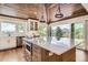 Bright kitchen boasts an island, wood ceiling, stainless steel appliances and scenic mountain views at 12196 W Belleview Dr, Littleton, CO 80127