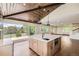 Modern kitchen featuring a large center island, pendant lighting, and sliding doors to the outdoor deck at 12196 W Belleview Dr, Littleton, CO 80127