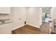 Bright laundry room features modern cabinetry, light countertops, and wood-look floors at 12196 W Belleview Dr, Littleton, CO 80127