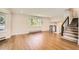 Bright living room features hardwood floors, large windows, and staircase with modern black railing at 12196 W Belleview Dr, Littleton, CO 80127