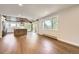 Open concept living space with hardwood floors, large windows, modern kitchen with island, and outdoor access at 12196 W Belleview Dr, Littleton, CO 80127