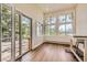 Sunroom features hardwood floors, and multiple windows overlooking a lush, green outdoor area at 12196 W Belleview Dr, Littleton, CO 80127