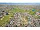 An aerial view showing a neighborhood, golf course and mountain views at 2247 Eagles Nest Dr, Lafayette, CO 80026