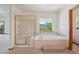 Bright bathroom boasts a glass-enclosed shower and a soaking tub by a window overlooking the trees at 2247 Eagles Nest Dr, Lafayette, CO 80026