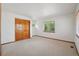Bright bedroom with a large window providing lots of natural light and a sizable closet with wooden doors at 2247 Eagles Nest Dr, Lafayette, CO 80026