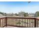 Balcony with wooden railing overlooking lush green landscaping and nearby home at 2247 Eagles Nest Dr, Lafayette, CO 80026