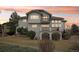 Stylish home featuring a tiered deck, well-maintained lawn, and mature trees against a vibrant sunset backdrop at 2247 Eagles Nest Dr, Lafayette, CO 80026