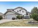 Charming two-story home features stone accents, an attached garage, and a well-manicured lawn at 2247 Eagles Nest Dr, Lafayette, CO 80026