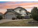 Beautiful home exterior featuring stone accents, a well-manicured lawn and an attached garage at 2247 Eagles Nest Dr, Lafayette, CO 80026