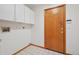 Bright laundry room with tile flooring, upper cabinets, and utility hookups, providing a practical space at 2247 Eagles Nest Dr, Lafayette, CO 80026