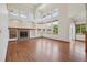 Bright living space with hardwood floors, tall windows, a fireplace, and built-in shelves at 2247 Eagles Nest Dr, Lafayette, CO 80026
