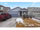 Charming two-story home featuring a covered porch, attached garage, and well-maintained front yard at 309 Spruce St, Bennett, CO 80102