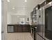 Well-lit kitchen features stainless steel appliances, dark wood cabinetry, and view to living room at 309 Spruce St, Bennett, CO 80102