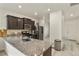 Charming kitchen with stainless steel appliances, island, and dark wood cabinetry at 309 Spruce St, Bennett, CO 80102