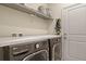 Modern laundry room featuring sleek LG washer and dryer units, ample counter space, and convenient shelving at 309 Spruce St, Bennett, CO 80102