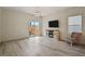 Bright living room features modern fireplace, hardwood floors, and sliding door to backyard at 309 Spruce St, Bennett, CO 80102