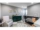 Bedroom featuring a dark green changing table and a baby's crib filled with stuffed animals at 256 Ash St, Bennett, CO 80102