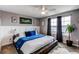 Bright primary bedroom with dark curtains and blue accents to compliment the bed and modern decor at 256 Ash St, Bennett, CO 80102
