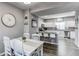 Open-concept dining area with a view of the kitchen, featuring a breakfast bar and modern appliances at 256 Ash St, Bennett, CO 80102