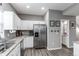 Well-lit kitchen boasting stainless steel appliances, granite countertops, and sleek white cabinets at 256 Ash St, Bennett, CO 80102