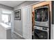 Conveniently located laundry closet featuring a stacked washer and dryer unit in a hallway at 256 Ash St, Bennett, CO 80102