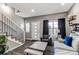 Cozy living room with hardwood floors, a modern staircase, a large window, and stylish furnishings at 256 Ash St, Bennett, CO 80102