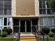 Building 207 entrance featuring glass doors and a well-maintained walkway, flanked by greenery at 3022 S Wheeling Way # 107, Aurora, CO 80014